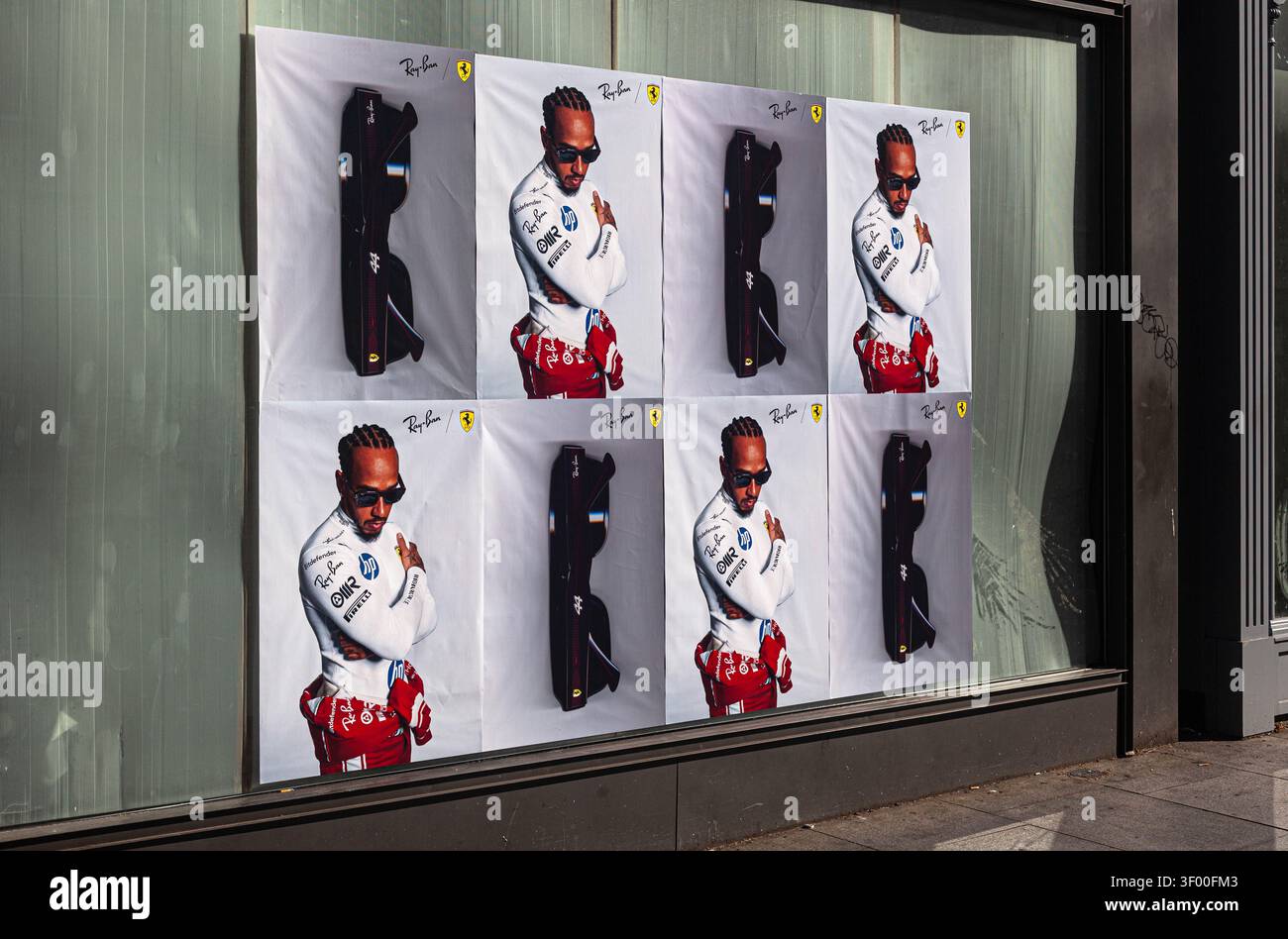 Una serie di poster su una vetrina di un negozio con Lewis Hamilton che pubblicizza gli occhiali da sole Ray-Ban per X Scuderia Ferrari, Londra, Inghilterra, Regno Unito. Foto Stock
