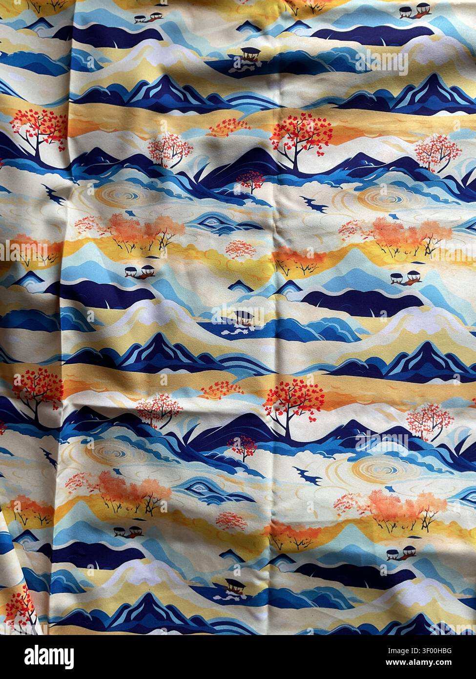 Stampa su tessuto giapponese colorata con un paesaggio stilizzato con montagne blu, alberi rossi autunnali Foto Stock