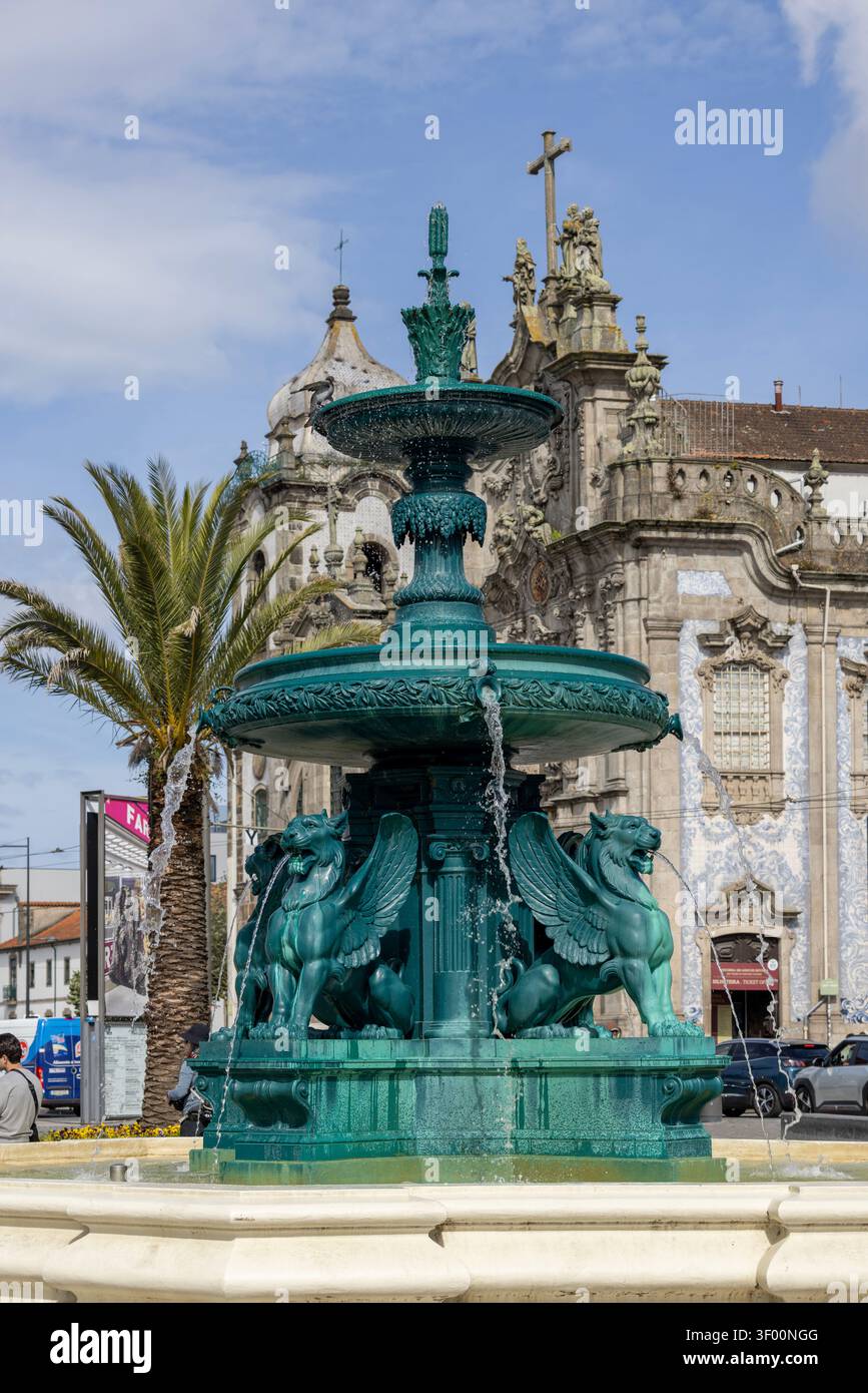 Porto, Portogallo - 12 maggio 2026: Storica Fontana verde dei Leoni fonte dos Leoes con sculture di leoni alati. Facciata barocca della chiesa Igreja do Carmo Foto Stock