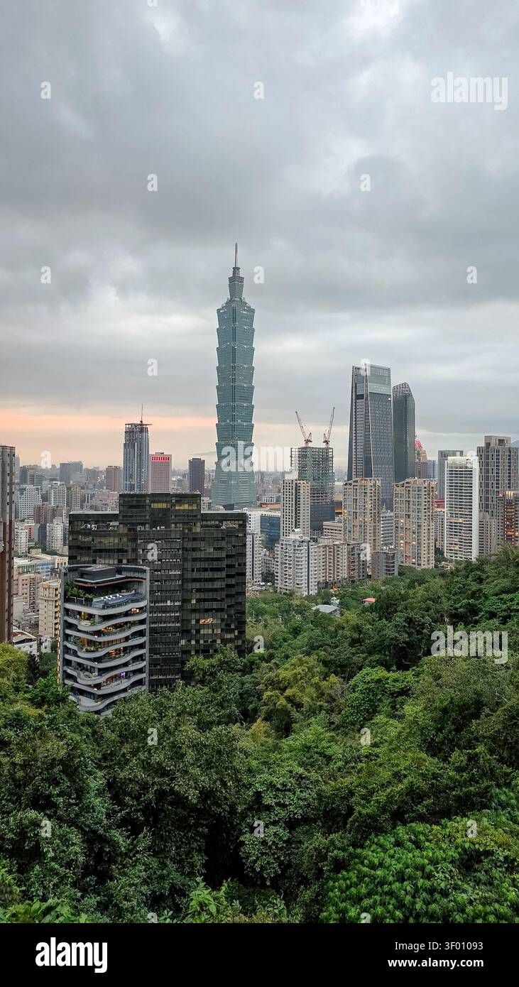 Affascinante vista di Taipei, che mette in risalto il grattacielo Taipei 101, dalla lussureggiante vegetazione del Monte Elefante. Questa iconica scena cattura il carattere urbano Foto Stock