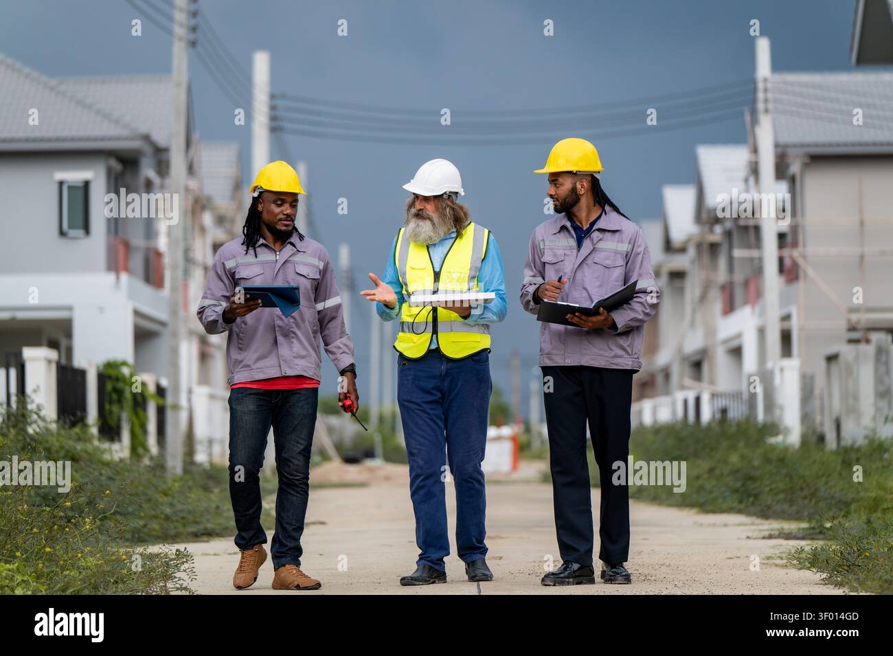 Gli ingegneri hanno discusso la preparazione per l'installazione di piccoli pannelli solari nelle aree di costruzione di villaggi residenziali per progetti di energia sostenibile e di improvvisazione Foto Stock
