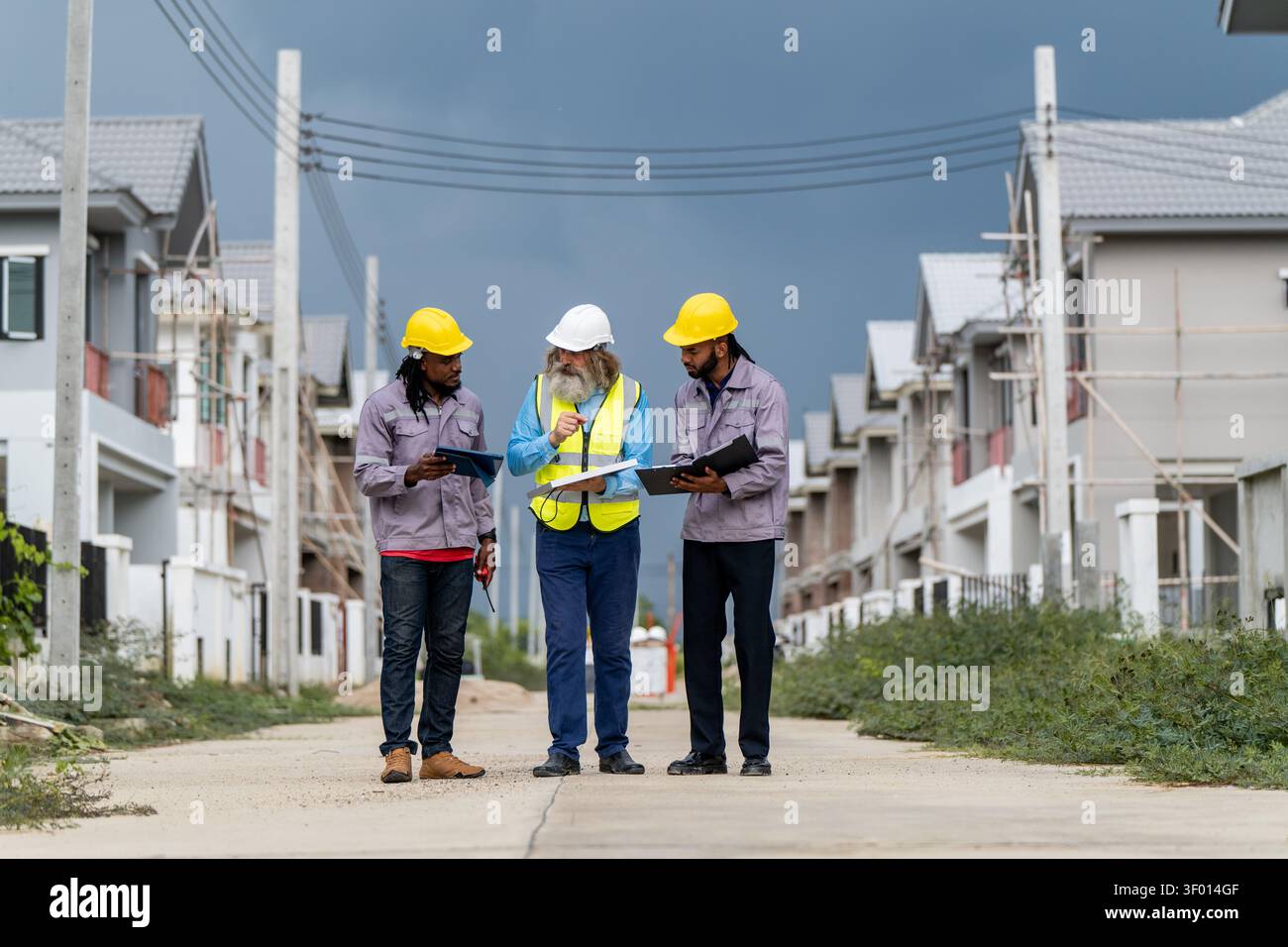 Gli ingegneri hanno discusso la preparazione per l'installazione di piccoli pannelli solari nelle aree di costruzione di villaggi residenziali per progetti di energia sostenibile e di improvvisazione Foto Stock