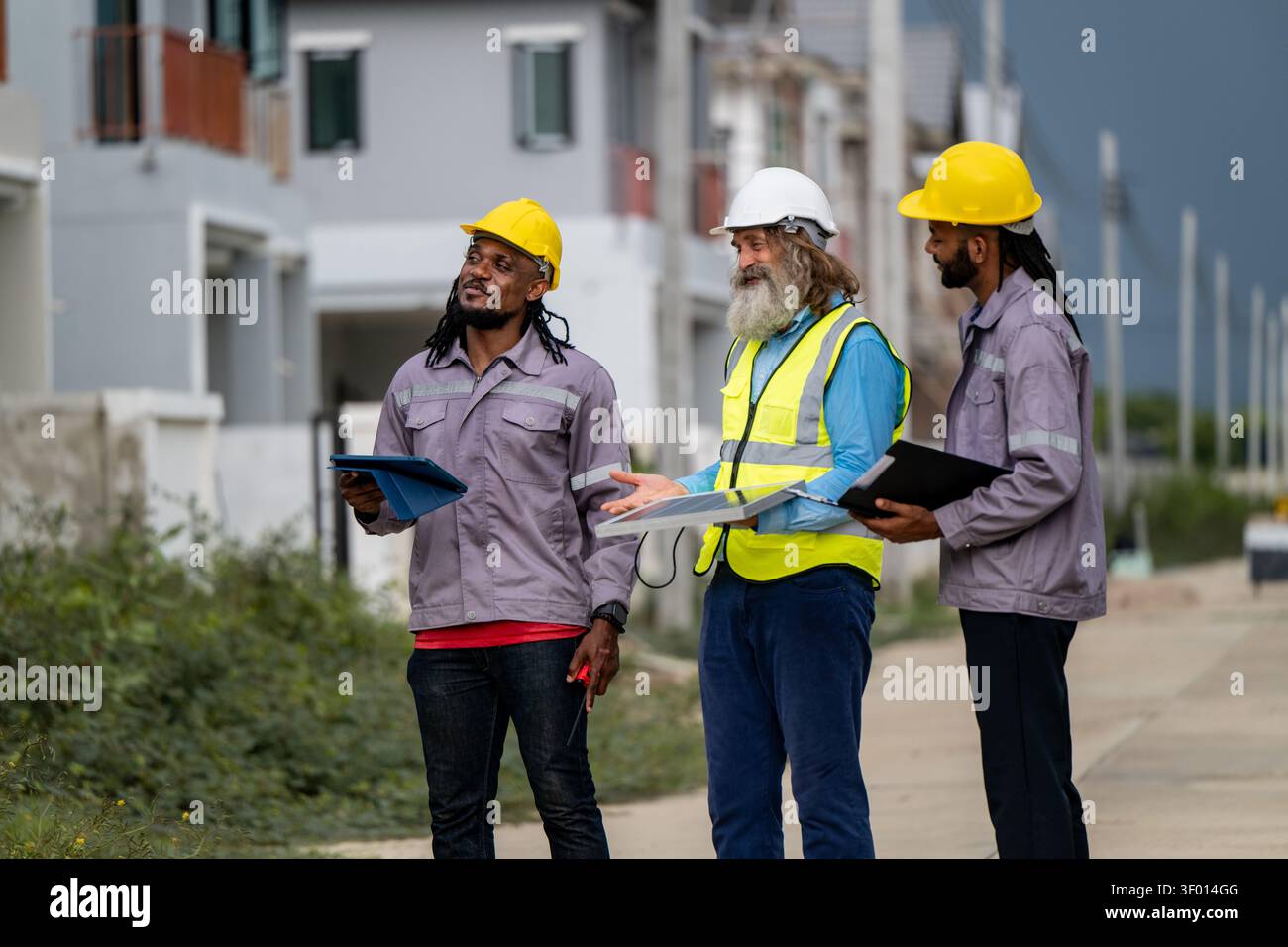 Gli ingegneri hanno discusso la preparazione per l'installazione di piccoli pannelli solari nelle aree di costruzione di villaggi residenziali per progetti di energia sostenibile e di improvvisazione Foto Stock