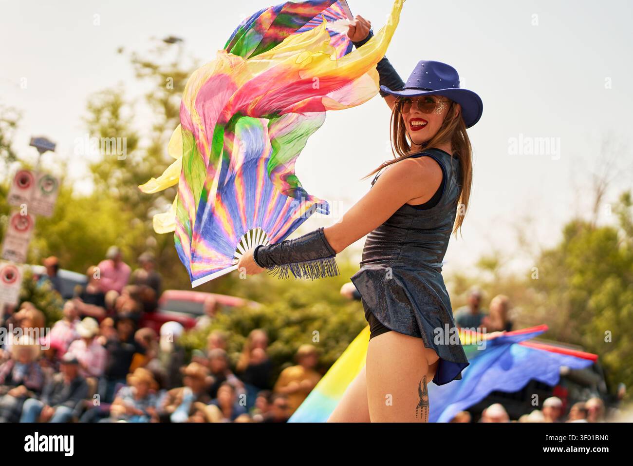 La ballerina cowgirl si esibisce con i fan colorati durante la Calgary Stampede Parade nel centro di Calgary. L'evento attrae grandi folle e mostra locali Foto Stock