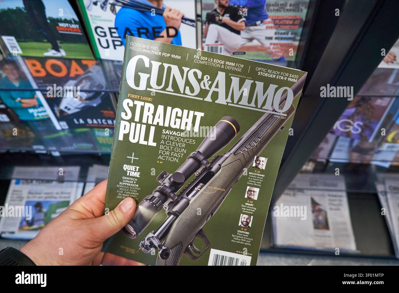 CHICAGO, il, USA - 3 MARZO 2021: Primo piano di una persona che detiene una rivista "Guns and Ammo" in un negozio. La copertina della rivista mette in evidenza argomenti come Foto Stock
