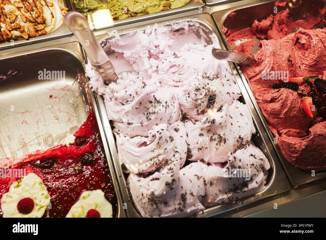 Assortimento di gusti di gelato e sorbetto alla frutta in contenitori espositivi. Sfondo di dessert ghiacciato per rinfresco estivo di dolci e prelibatezze colorate. Foto Stock