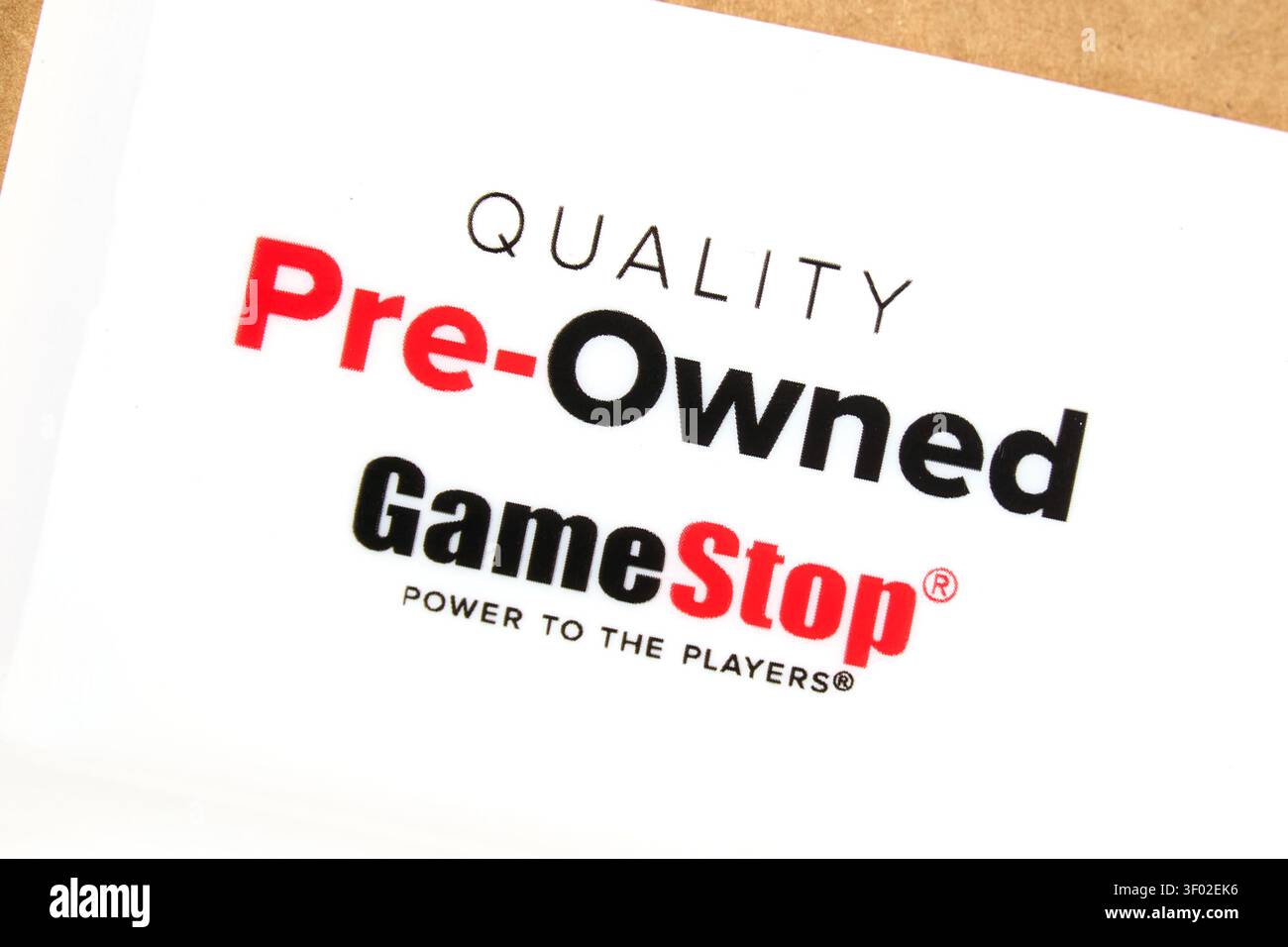 DALLAS, TX, USA - 16 FEBBRAIO 2024: Una fotografia ravvicinata del marchio GameStop su un foglio di carta, che mostra in modo preminente il testo "QUALITY Pre-Ow Foto Stock