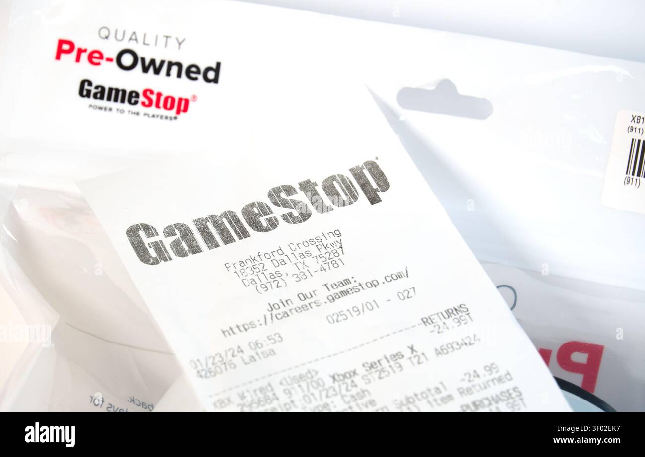 DALLAS, Texas, USA - 16 FEBBRAIO 2024: Un'immagine ravvicinata raffigura una ricevuta GameStop sopra una borsa GameStop con marchio, evidenziando un acquisto da parte di p. Foto Stock