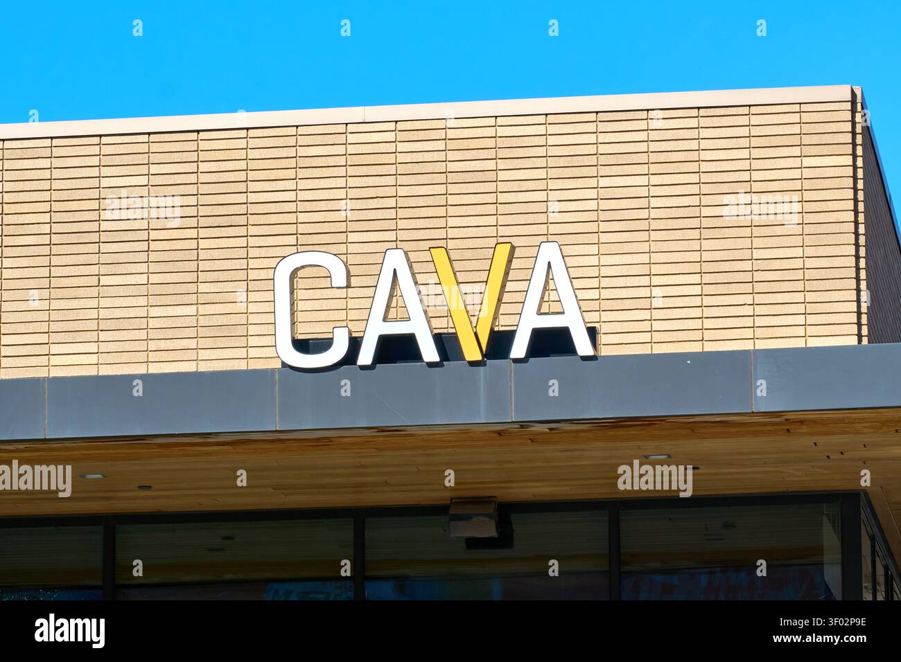 DALLAS, Texas, USA - 16 FEBBRAIO 2024: Un cartello del ristorante CAVA è esposto in modo prominente su una facciata in mattoni. Il cartello riporta il marchio "CAVA" in WHI Foto Stock