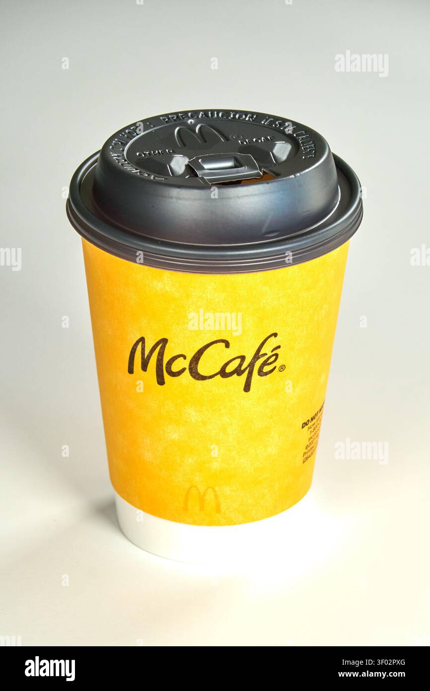 DALLAS, Texas, USA - 16 FEBBRAIO 2024: Una tazza da caffè con marchio McCafé dal design giallo brillante e coperchio in plastica nero. Il logo McCafé è Foto Stock