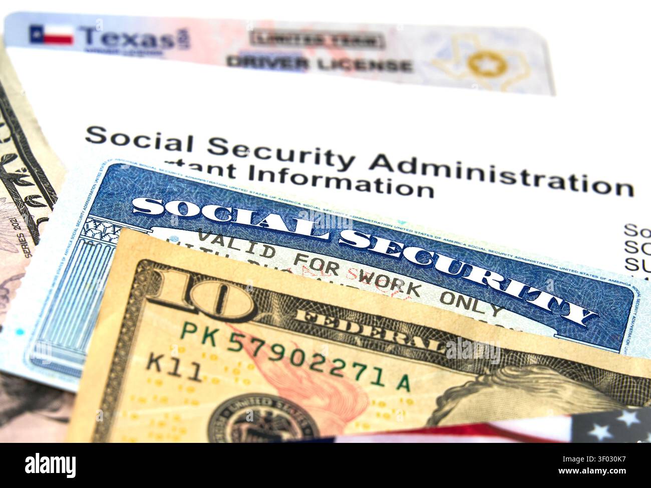 CARROLLTON, Texas, USA - 22 FEBBRAIO 2024: Vista ravvicinata con patente di guida del Texas, tessera di sicurezza sociale e bollette in dollari USA insieme a una Socia Foto Stock