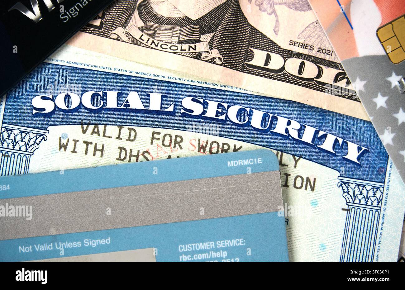 CARROLLTON, Texas, Stati Uniti - 22 FEBBRAIO 2024: Primo piano dettagliato di una carta di sicurezza sociale statunitense insieme a una carta di debito blu e una banconota in dollari USA, Highligh Foto Stock
