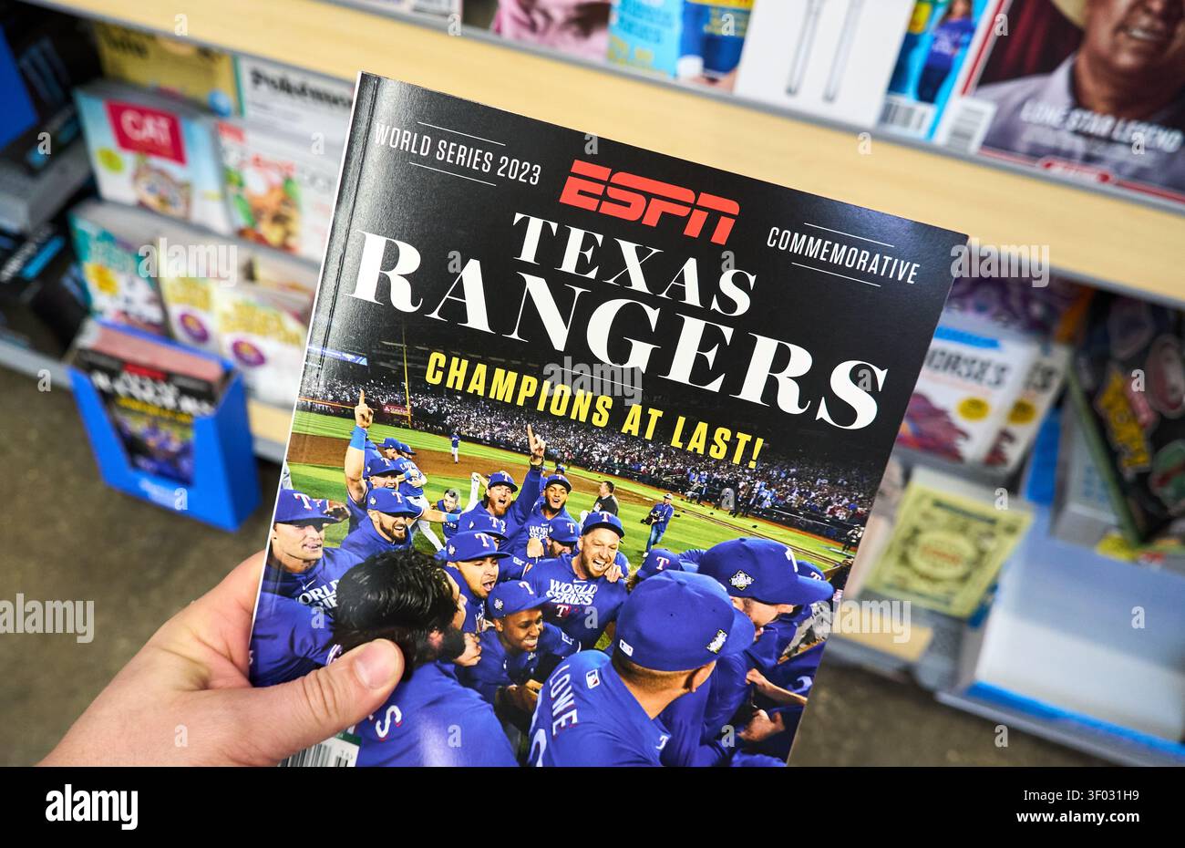 CARROLLTON, Texas, USA - 24 FEBBRAIO 2024: Una persona detiene una rivista commemorativa ESPN che celebra la vittoria dei Texas Rangers alle World Series 2023 Foto Stock