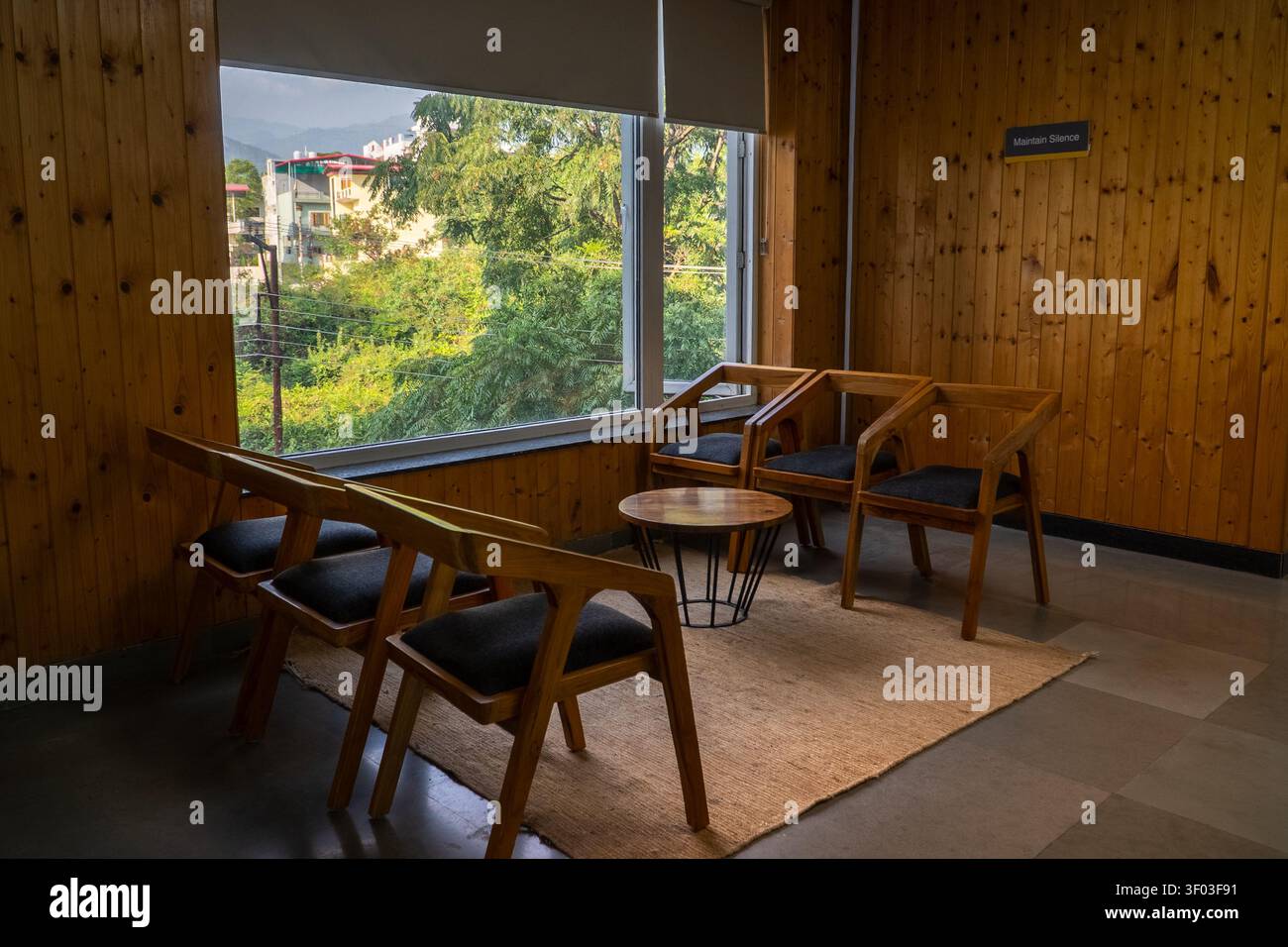Area d'attesa moderna con sedie di legno e design d'interni minimalista Foto Stock