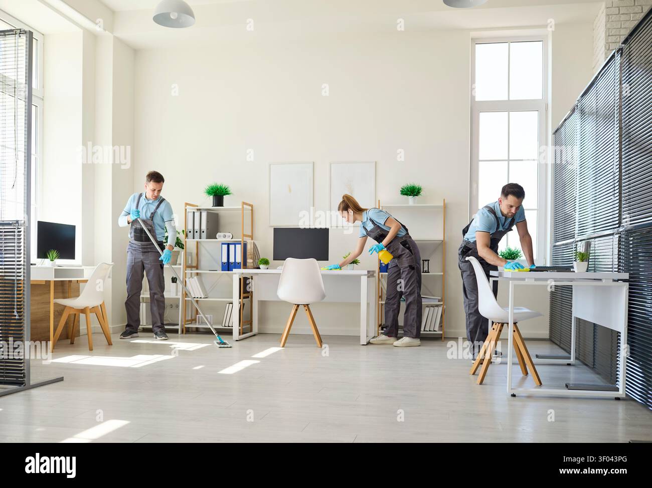 Team di pulizia professionale per uffici che pulisce lo spazio di lavoro con materiali e strumenti Foto Stock