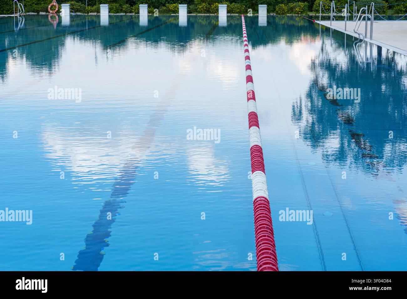 Piscina all'aperto vuota con corda per corsie e riflessi Foto Stock