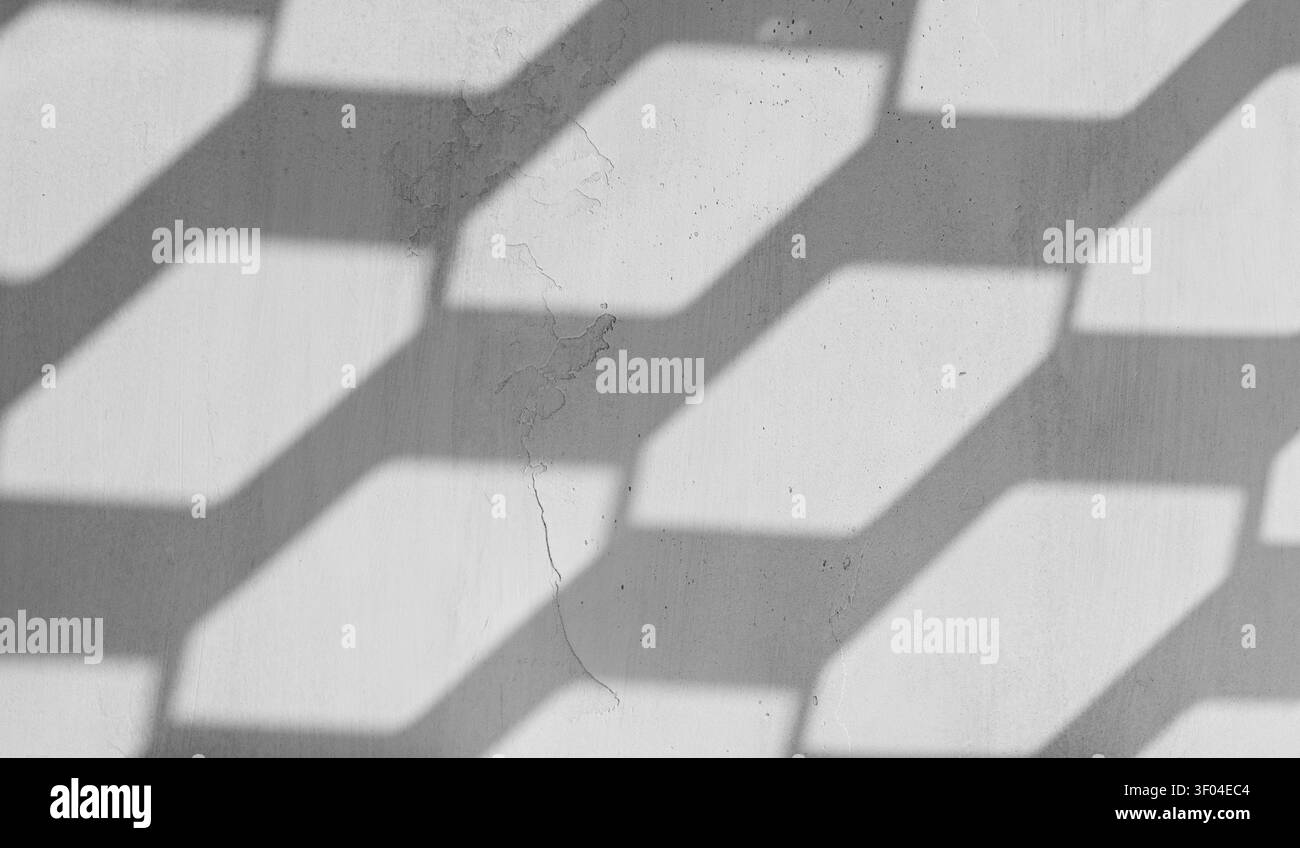Ombre geometriche sulla vecchia parete in gesso che creano una scena di mockup vuota con motivo grigio astratto Foto Stock