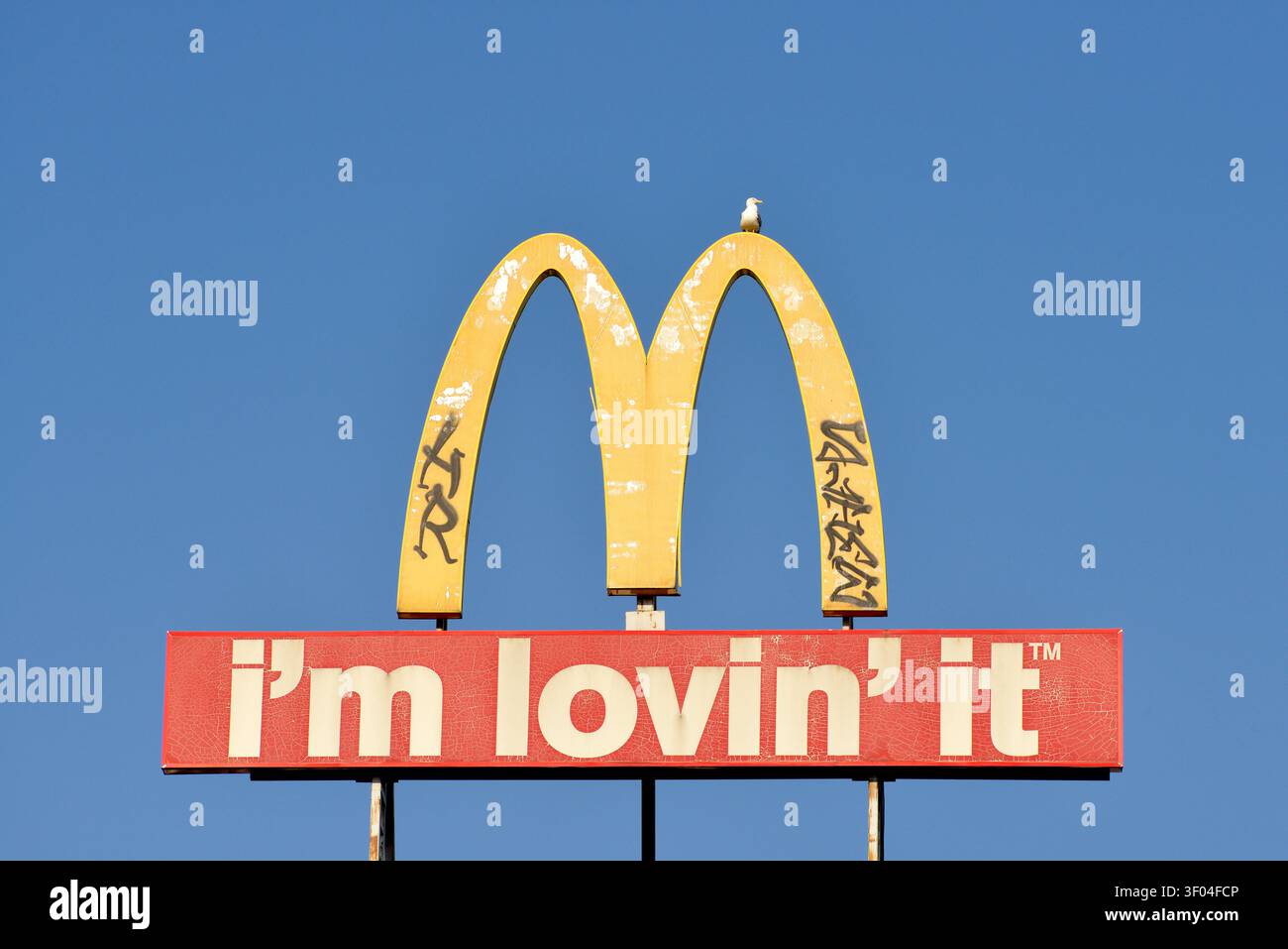 Vecchia pubblicità datata con il logo ad arco di McDonald's, graffiti e un gabbiano sopra, a Sofia, Bulgaria, Europa Orientale, Balcani, UE Foto Stock