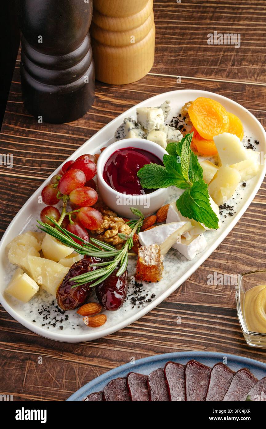 Tagliere di formaggi gourmet con frutta e noci assortite Foto Stock