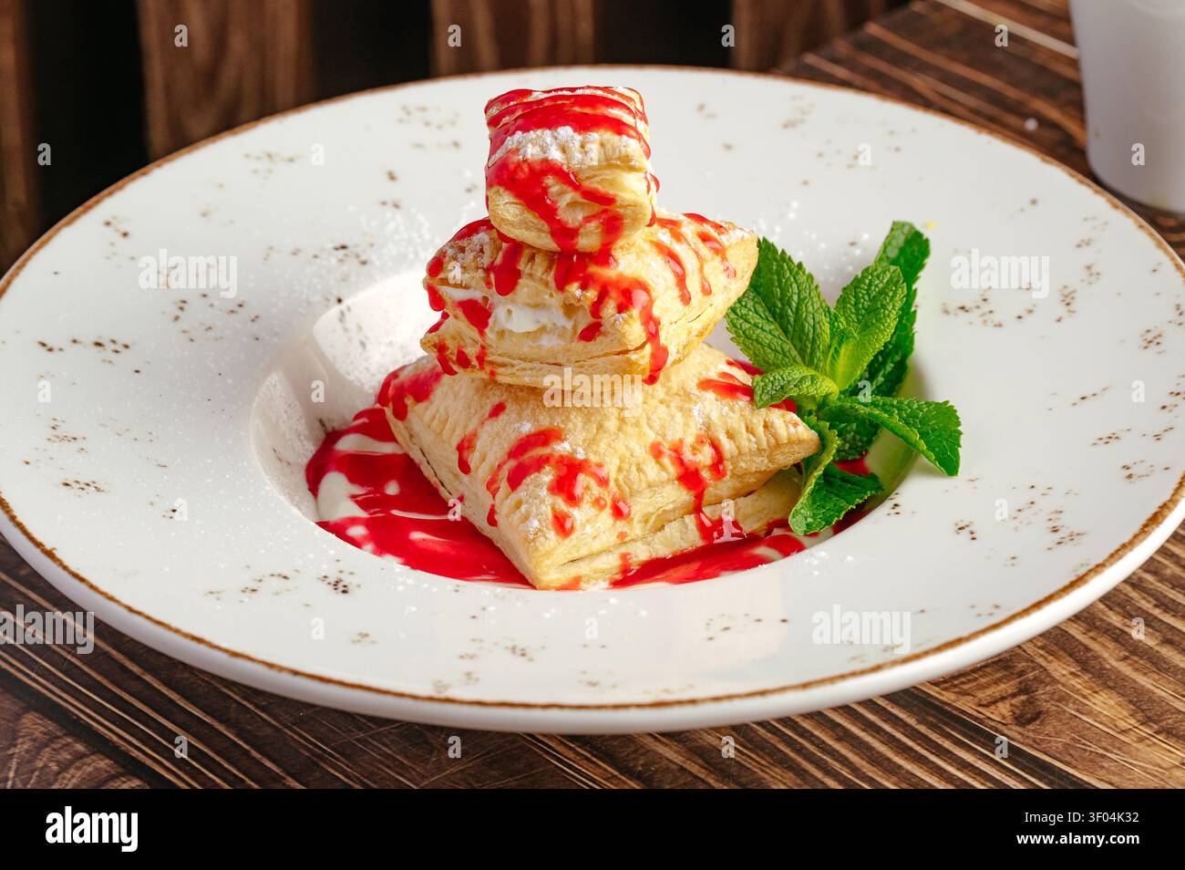 Pila di pasta cremosa con salsa di frutti di bosco e menta Foto Stock