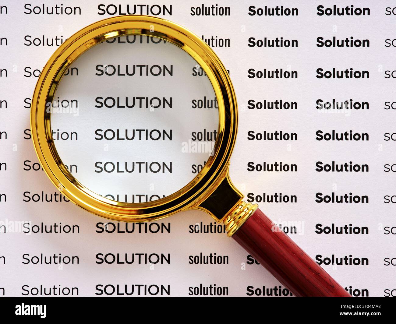 Lente d'ingrandimento focalizzata sul testo SOLUZIONE, che simboleggia la ricerca di una soluzione, l'analisi della soluzione o la risoluzione del problema Foto Stock