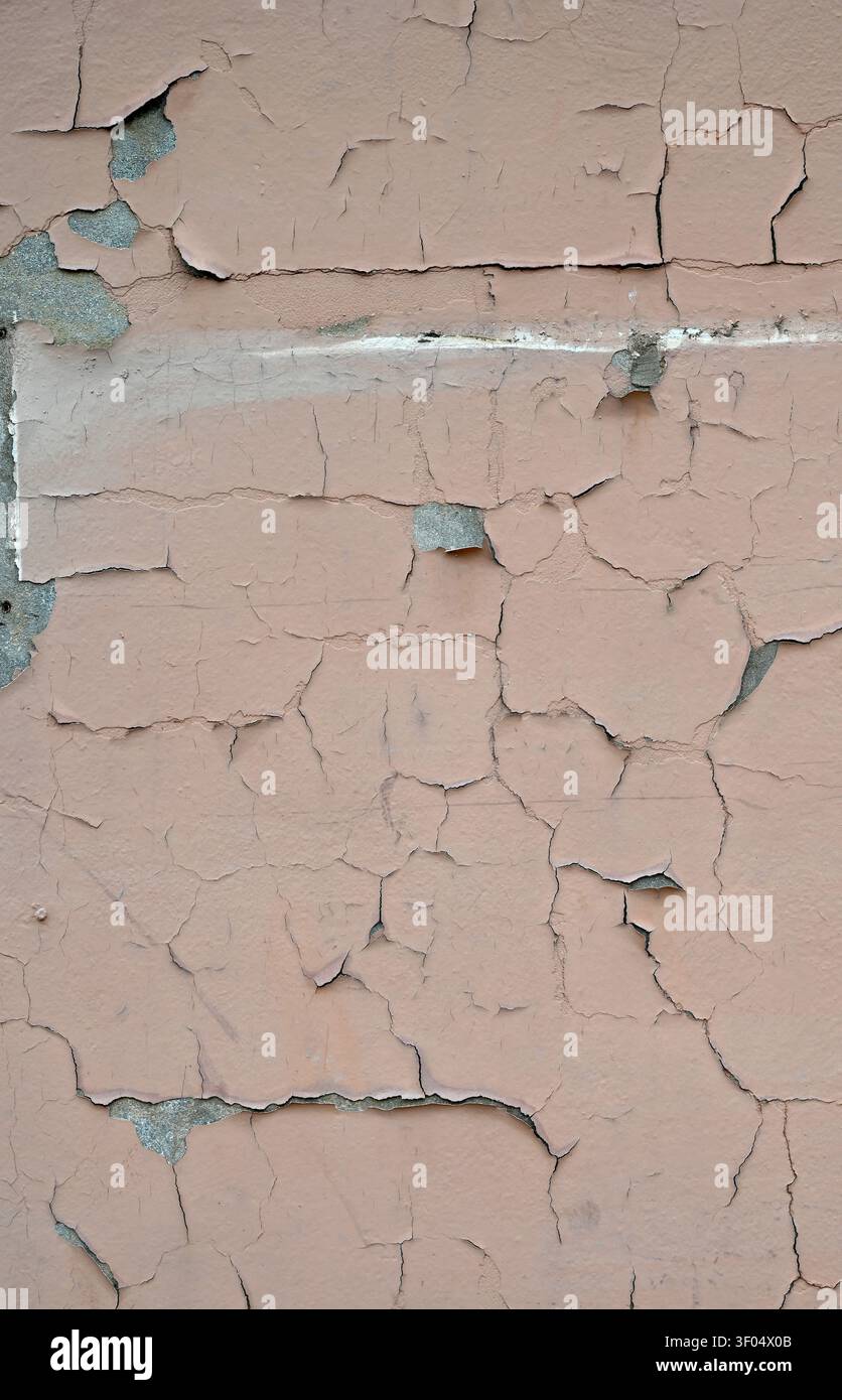 Prima verticale di una superficie murale dipinta di un marrone chiaro invecchiata con vernice scrostata, crepata e sfaldante Foto Stock