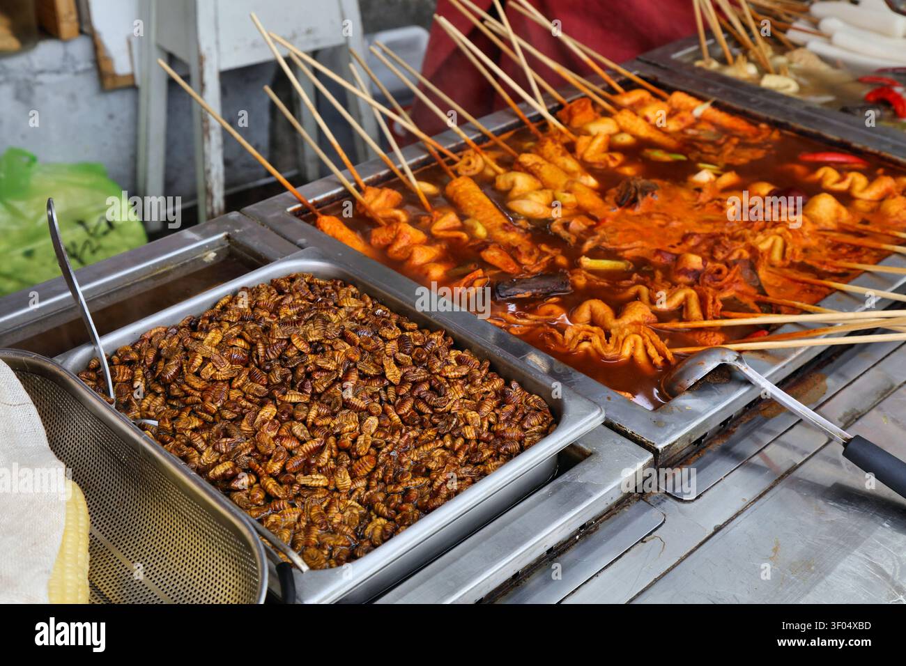 Pupa di bachi da seta - snack Street food a Busan, Corea del Sud. Insetti come cibo. Foto Stock