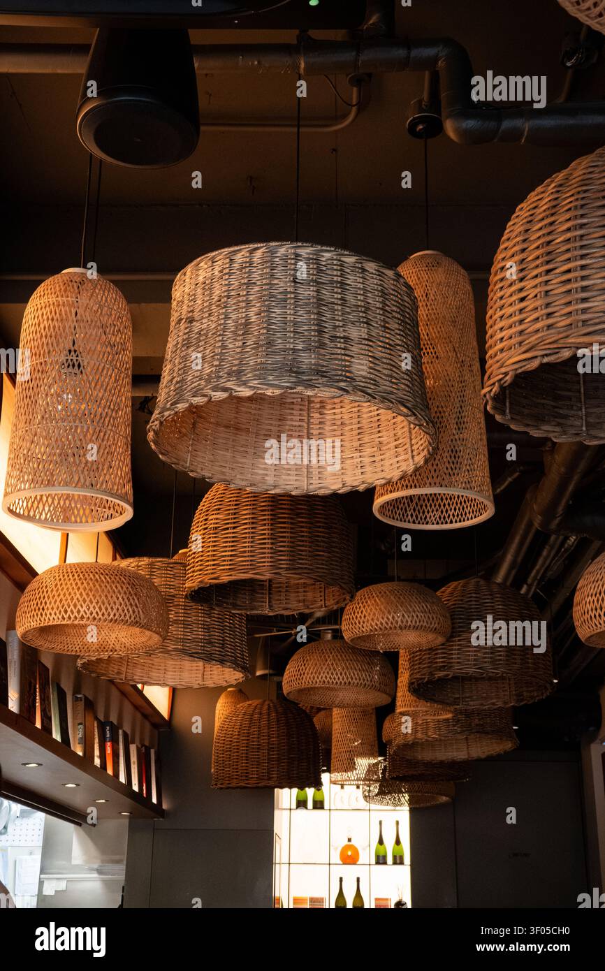 Lampade a sospensione in rattan intrecciato caldo in un interno accogliente di ristorante Foto Stock