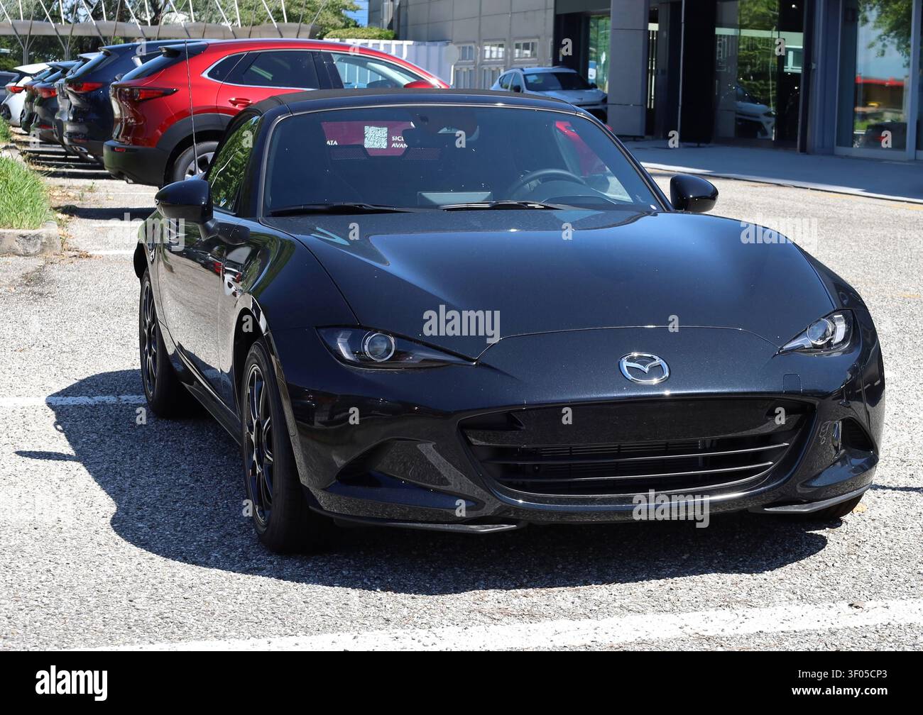 Udine, Italia. 28 giugno 2025. Mazda MX-5 nero, noto anche come Mazda Miata o Roadster, davanti alla concessionaria ufficiale. Foto Stock