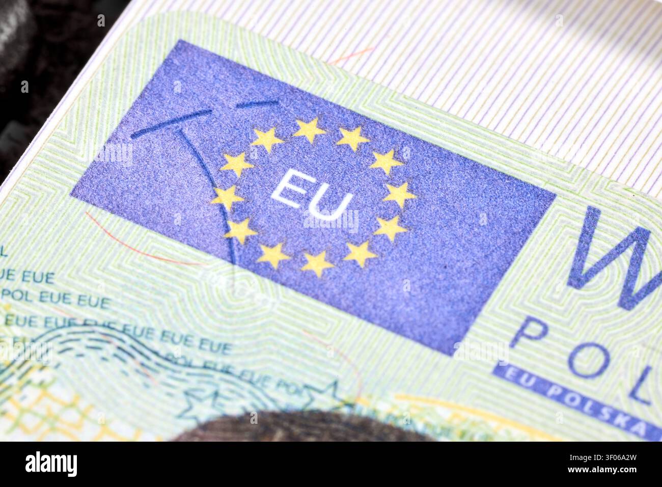 Frammento di adesivo per visto Schengen polacco all'interno del passaporto di viaggio che mostra caratteristiche di sicurezza come stelle olografiche dell'Unione europea, guilloché intricato p Foto Stock