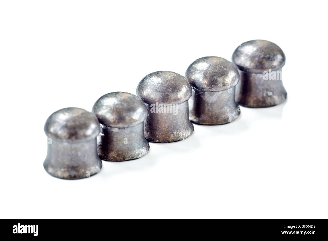 File di proiettili a cupola per fucile ad aria compressa mostrati in primo piano su sfondo bianco. I proiettili di piombo metallico presentano teste arrotondate e bordi svasati per una traiettoria stabile Foto Stock