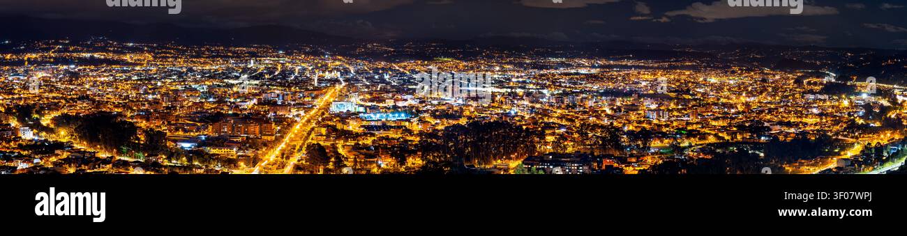 Un'ampia vista panoramica della città illuminata di Cuenca in Ecuador di notte, vista dal punto panoramico di Turi. Foto Stock