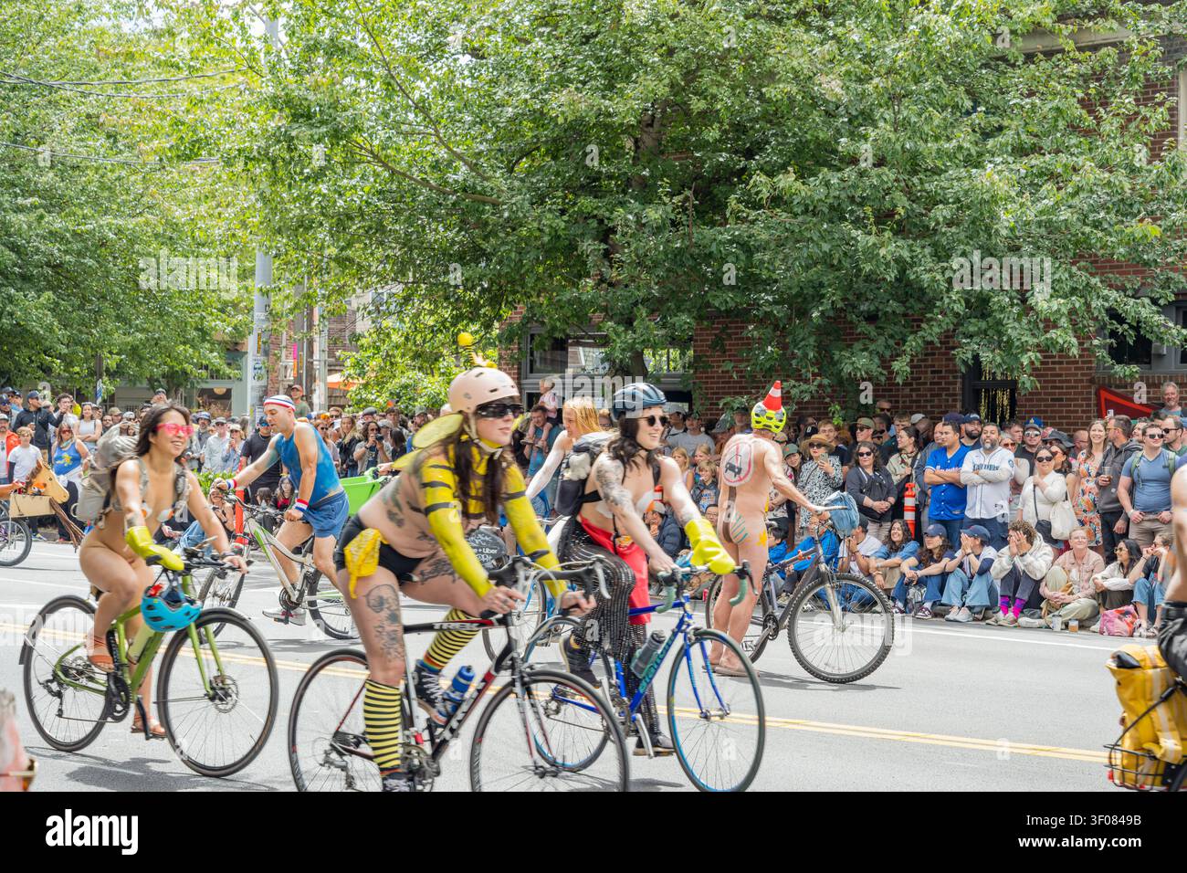 Stato di Washington, Stati Uniti, 20 giugno 2026 - le persone che indossano costumi e caschi colorati viaggiano in bicicletta lungo una strada costeggiata da spettatori Foto Stock