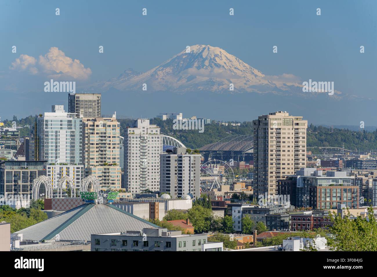 Stato di Washington, Stati Uniti, 21 GIUGNO 2026 - Una veduta del paesaggio urbano di Seattle con grattacieli, una ruota panoramica e la cima innevata Foto Stock