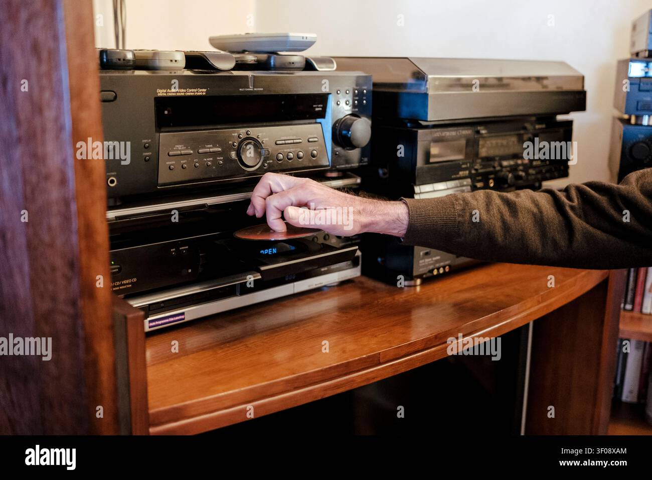 Mano di uomo che inserisce un vecchio CD in un lettore audio retrò Foto Stock