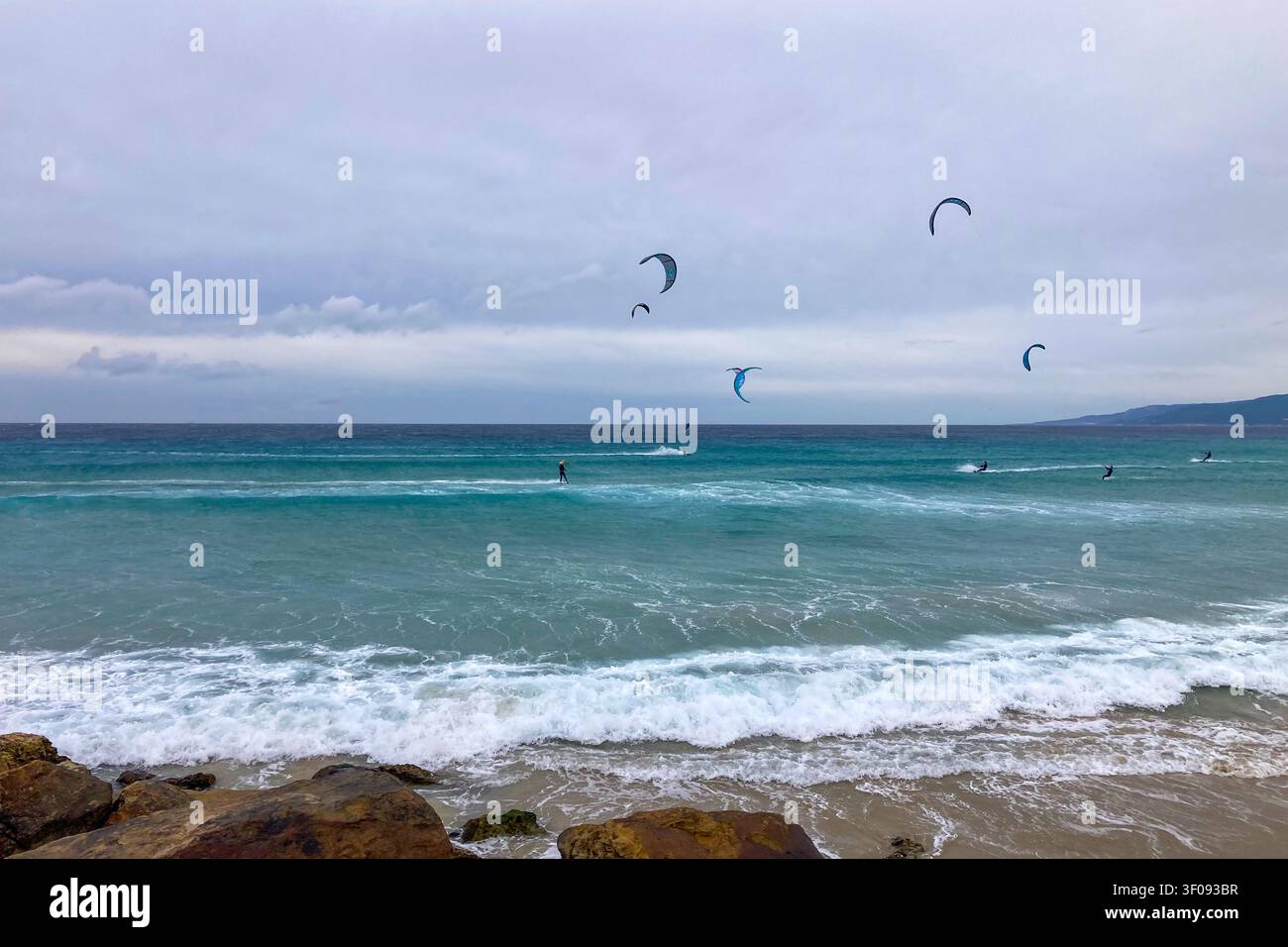 TARIFA, SPAGNA - 2 GENNAIO 2026: Un windsurfista cavalca forti venti atlantici al largo di Tarifa, in Spagna, catturando velocità, libertà ed energia costiera. - Immagine stock catturata con smartphone