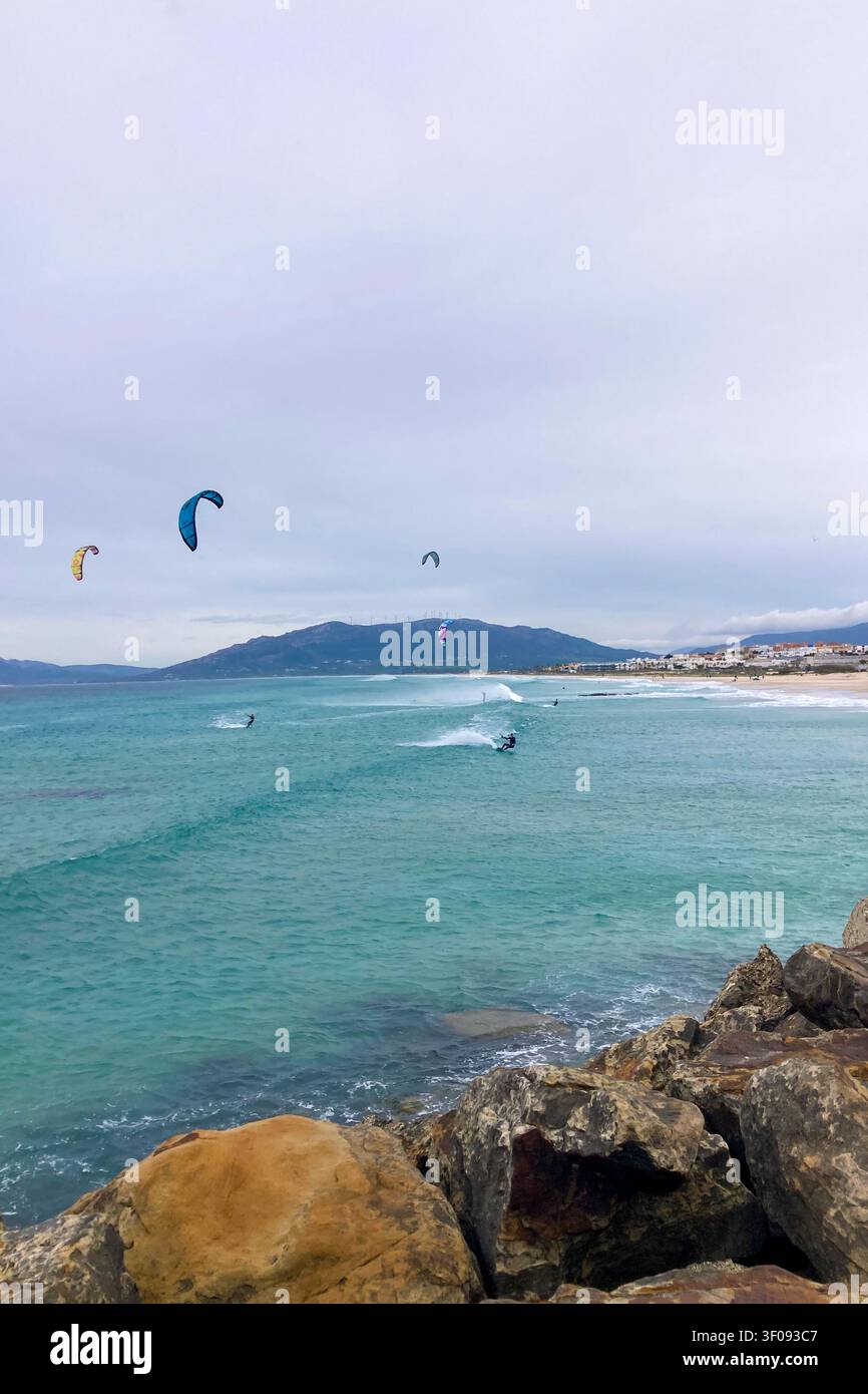 TARIFA, SPAGNA - 2 GENNAIO 2026: Un windsurfista cavalca forti venti atlantici al largo di Tarifa, in Spagna, catturando velocità, libertà ed energia costiera. - Immagine stock catturata con smartphone