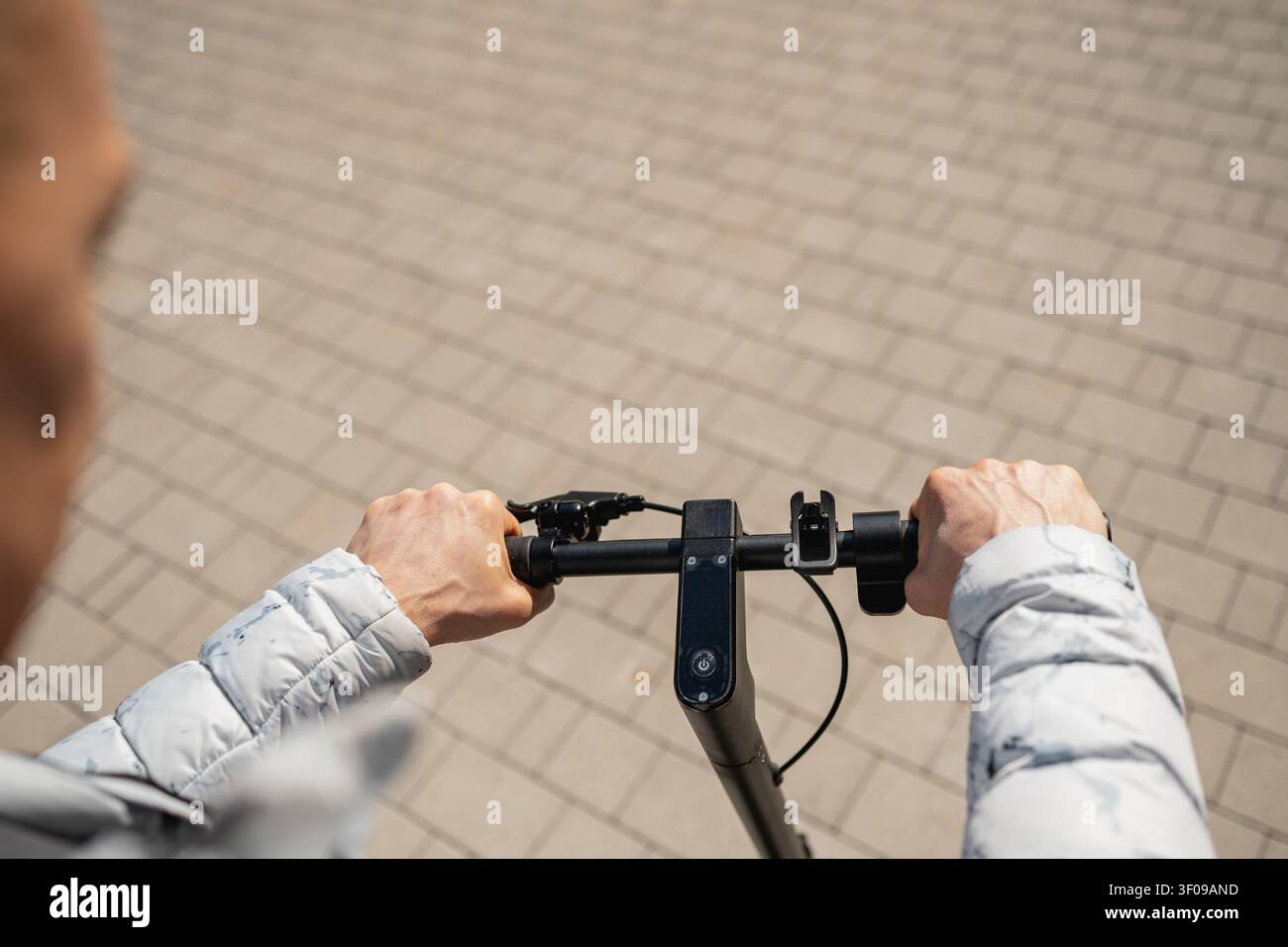 Vista in prima persona in sella a uno scooter elettrico in città Foto Stock