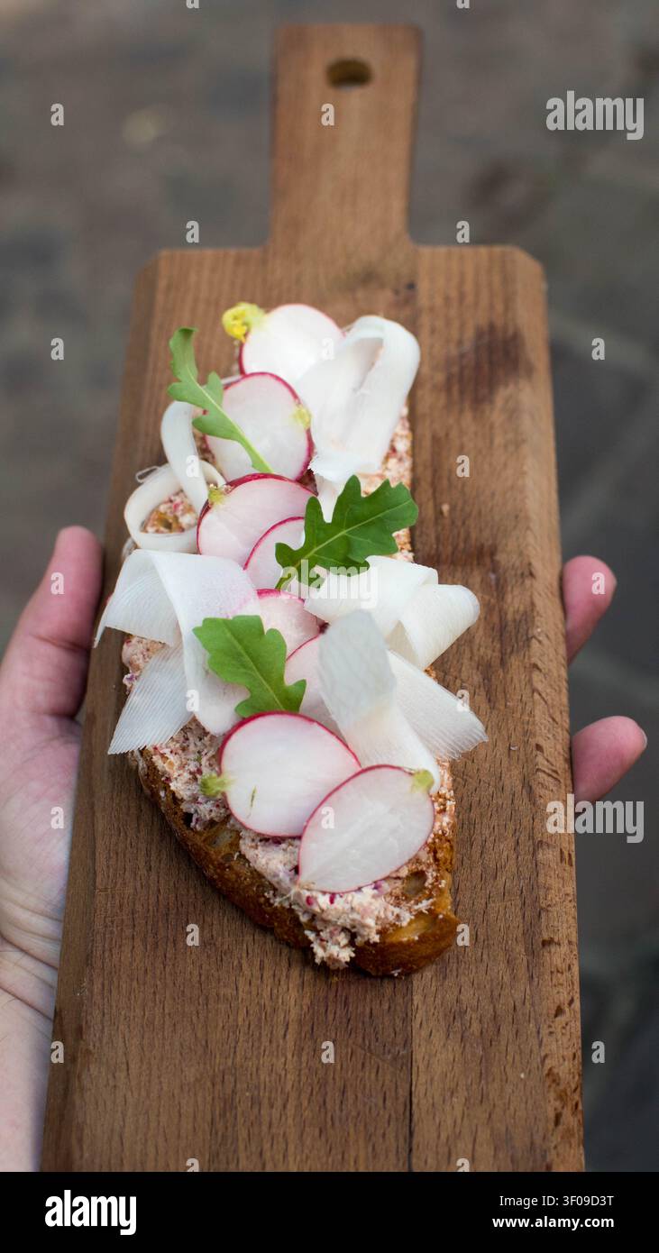Panino ai ravanelli aperto su tavola di legno rustica Foto Stock