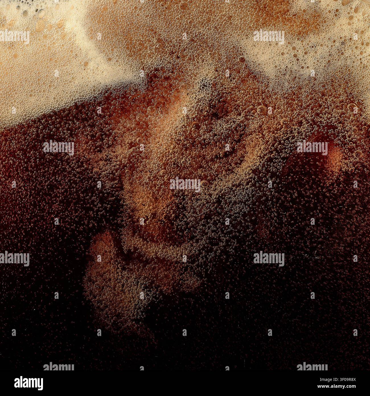 Schiuma di birra scura con bolle vorticose e consistenza cremosa della testa. Foto Stock
