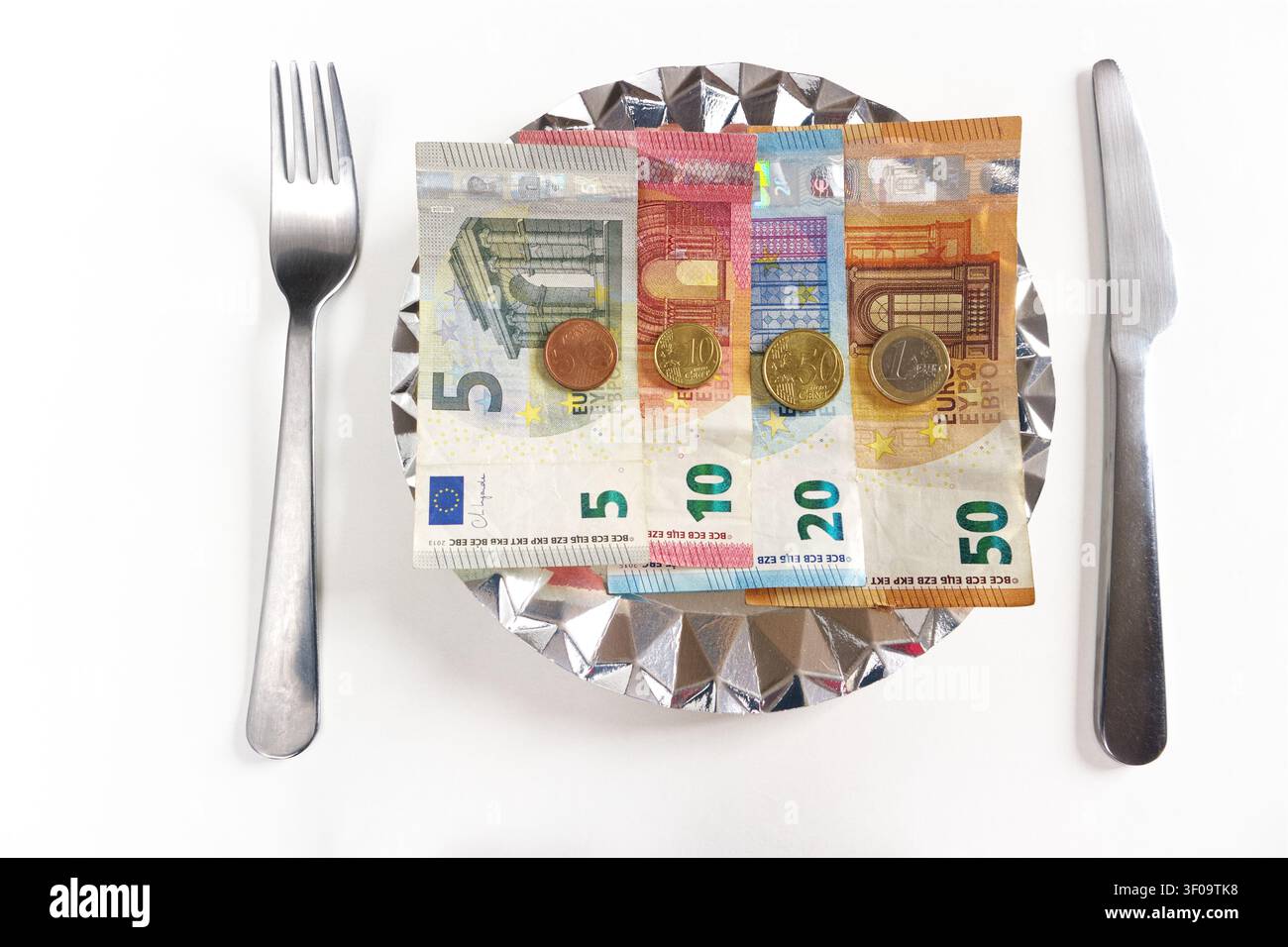 Monete e banconote in euro della Comunità Economica Europea. Con piatto, coltello e forchetta. Foto Stock