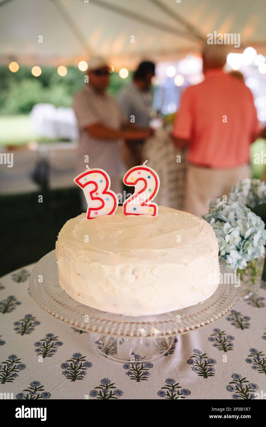 Torta di 32 anni glassata bianca a una festa in giardino all'aperto Foto Stock