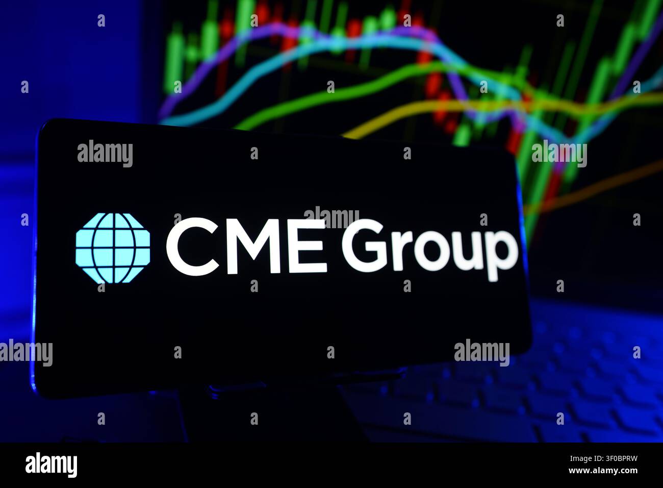 Logo di CME Group Global Derivatives Exchange and Financial Markets Company su smartphone con grafico delle prestazioni del mercato azionario Foto Stock