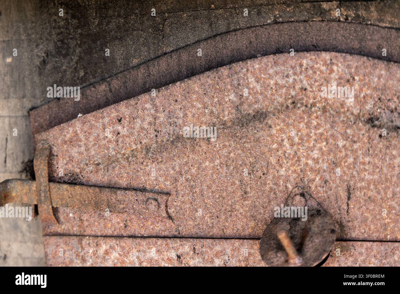 Vista dettagliata di metallo invecchiato e corrotto che mostra strati e un meccanismo di serratura vintage, evidenziando la texture e il degrado Foto Stock