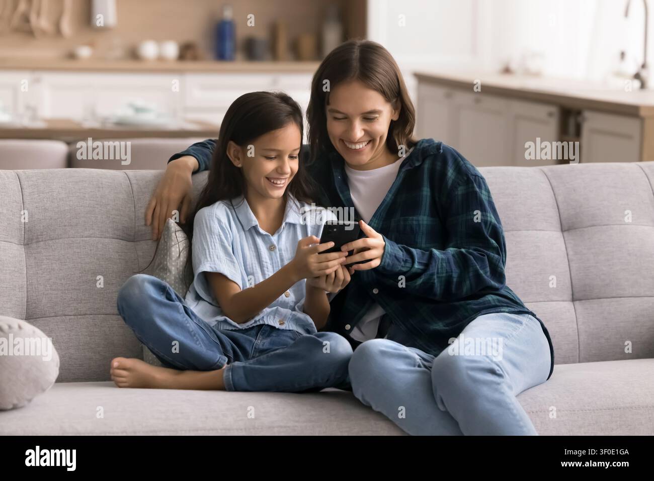 Mamma e bambino che usano uno smartphone, giocano, guardano video divertenti Foto Stock