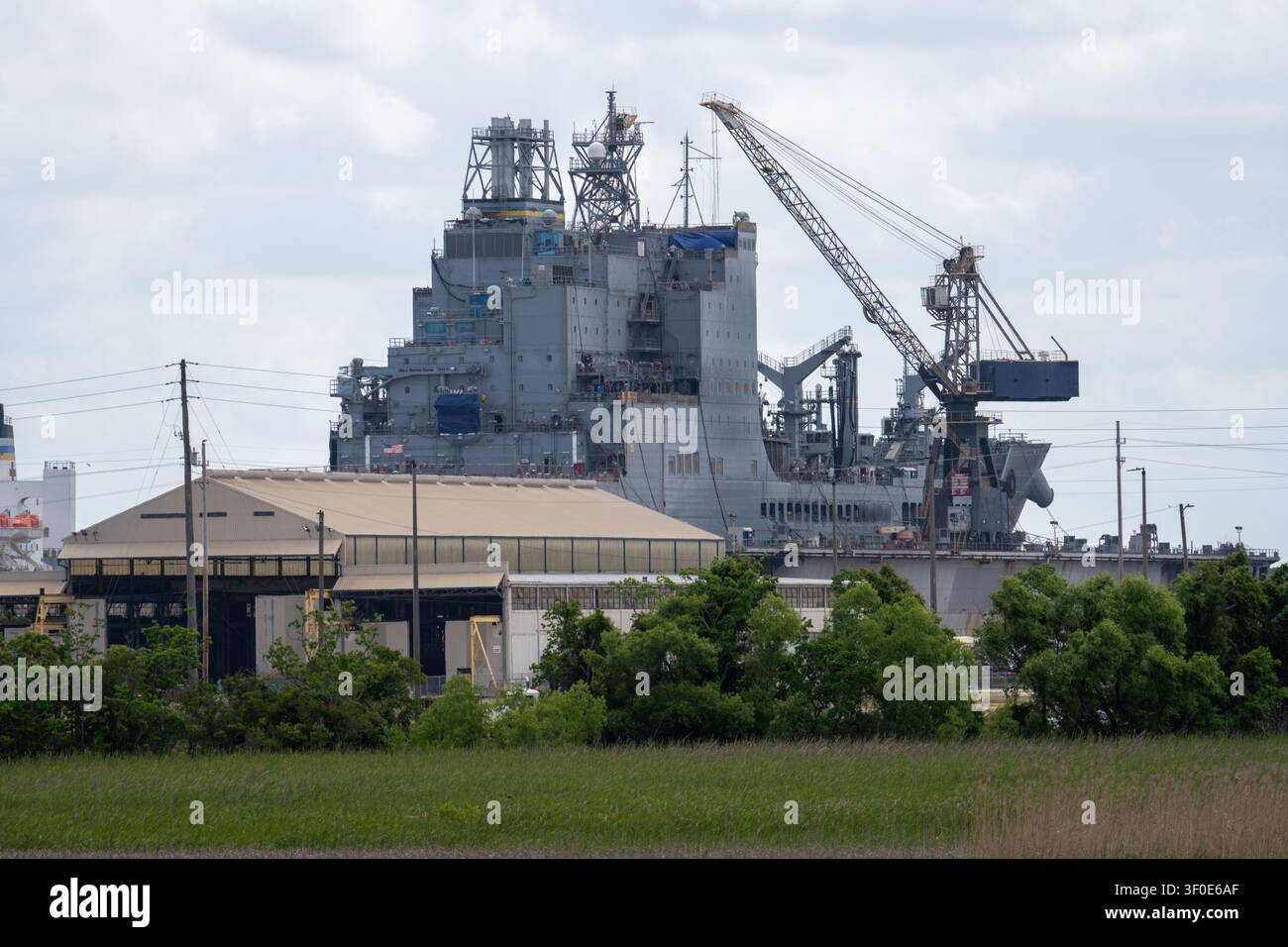 Mobile, AL - 2 maggio 25: Grande struttura di cantiere navale con gru e impianti di bacino di carenaggio visti attraverso la palude vicino al USS Alabama Battleship Memorial Park Foto Stock