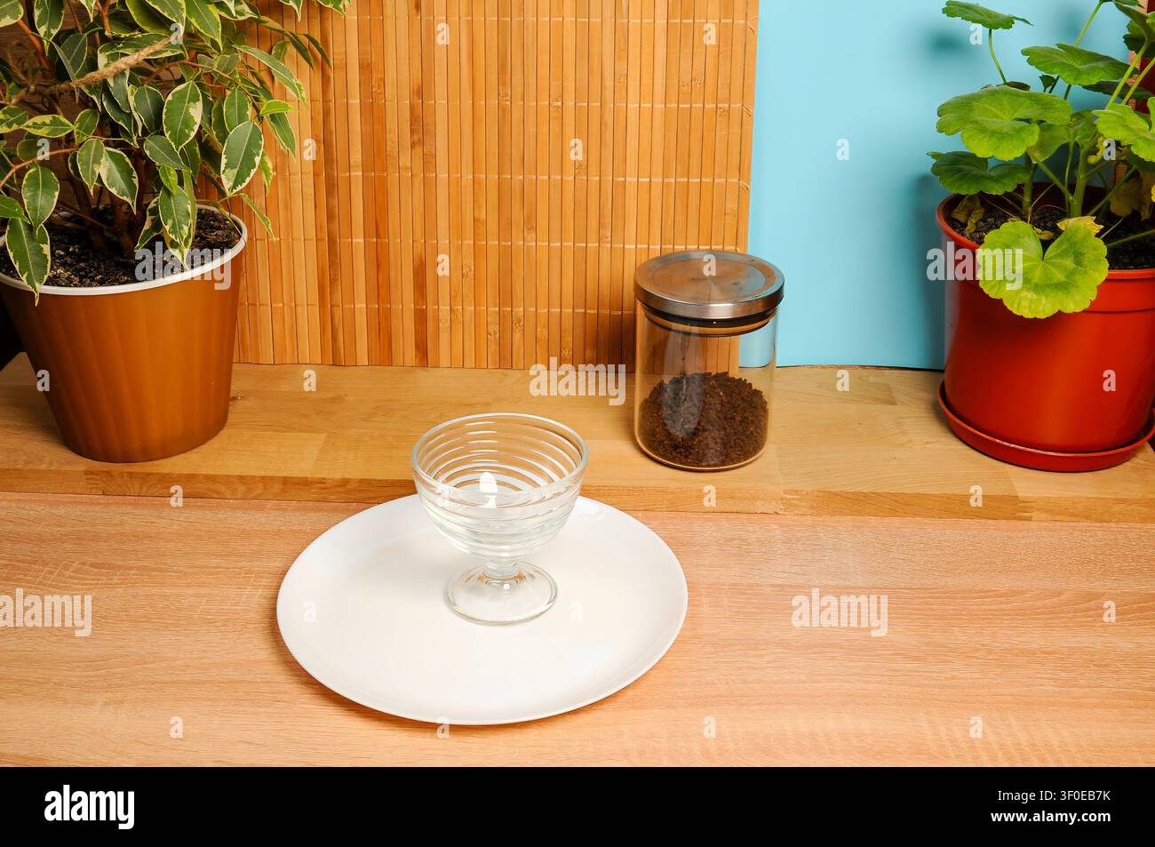 Natura morta con piante, caffè e una ciotola di vetro su una superficie di legno Foto Stock