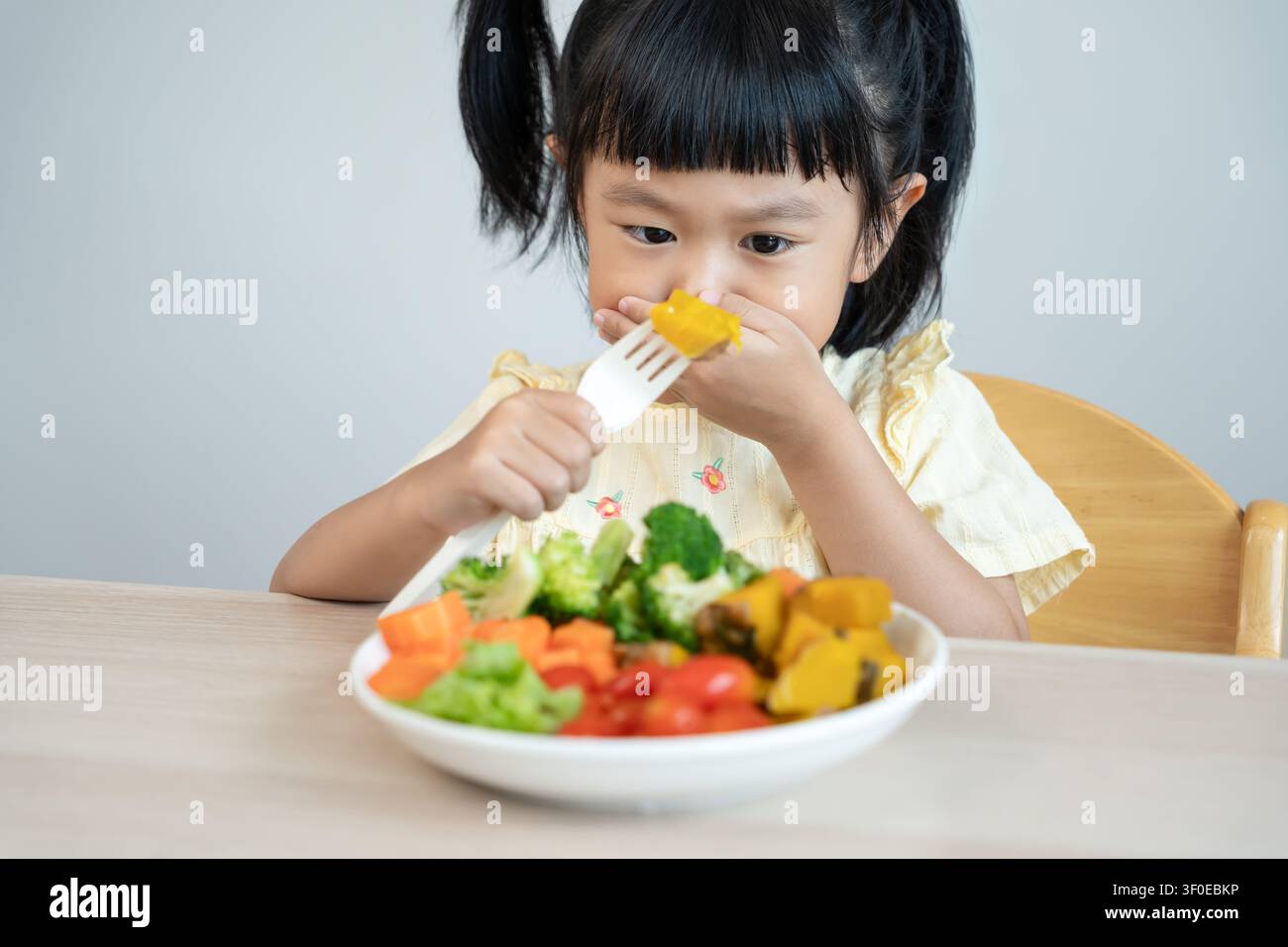 I bambini coprono la bocca senza mangiare verdure, sapore amaro, odore particolare, aspetto poco attraente, bruciare le verdure fuori dal piatto, rifiuto, nutrizione Foto Stock