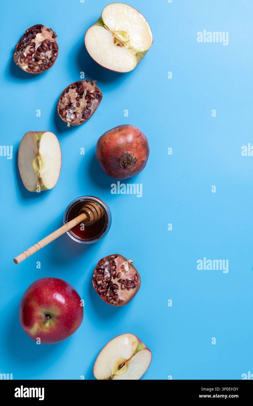 Rosh Hashanah tradizionale con mele, melagrane e miele su sfondo blu Foto Stock