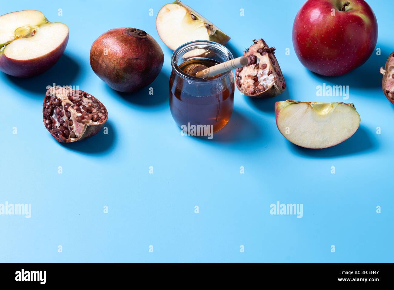 Rosh Hashanah tradizionale con mele, melagrane e miele su sfondo blu Foto Stock